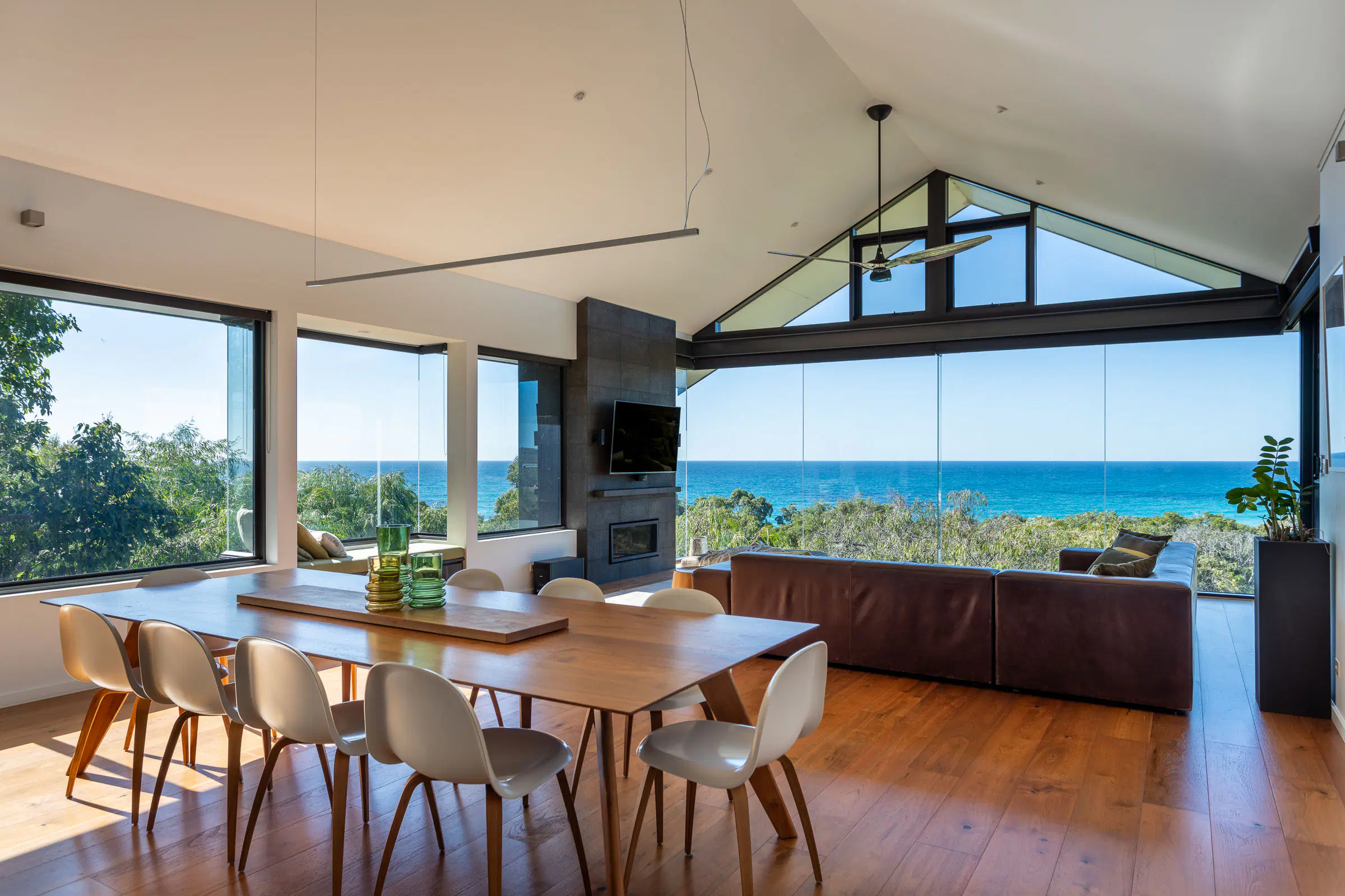The dining room and living room in one continuous space, open to the ocean